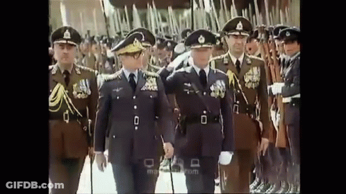 Men In Military Uniforms Walking In Line GIF