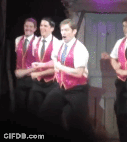 Men In Pink Vests And Ties On Stage GIF