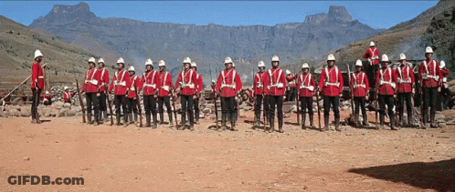 Men In Red Uniforms Lined Up With Mountains GIF