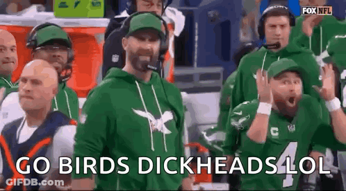 Men In Stadium Watching Football, One In Green Hoodie GIF