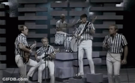 Men In Striped Shirts Playing Instruments On Stage GIF