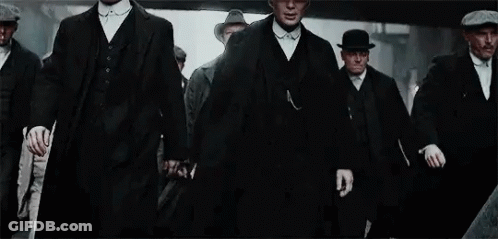 Men In Suits And Hats Walking Down City Street GIF