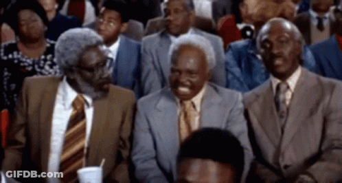 Men In Suits Laughing In Stadium GIF