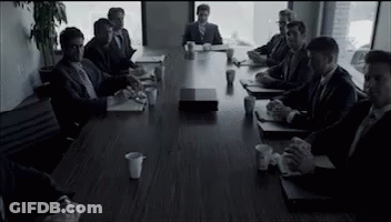 Men In Suits Sitting Around Conference Table GIF