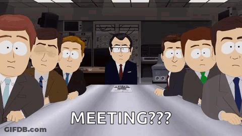 Men In Suits Sitting Around Table With Man At Head GIF