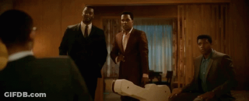 Men In Suits Standing Around Robot GIF