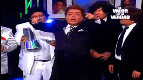 Men In Suits Standing Before Sign El Valor De La Verdad GIF