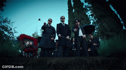 Men In Suits Standing Before Wreath GIF