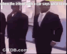 Men In Suits Standing In Hallway GIF