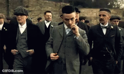 Men In Suits Walking Down Street One Smoking GIF