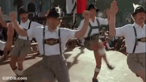 Men In Traditional German Clothing Dancing In A Line GIF