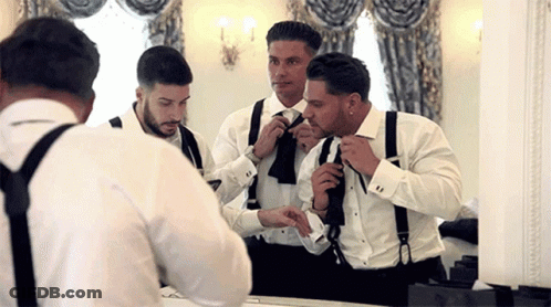 Men In Tuxedos And Suspenders Getting Ready In Front Of Mirror GIF