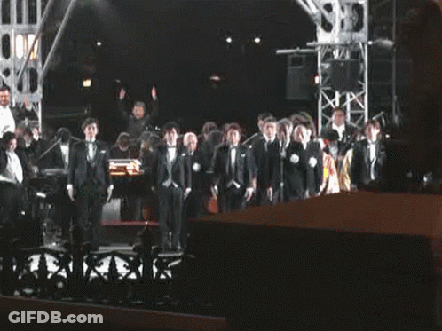 Men In Tuxedos On Stage GIF