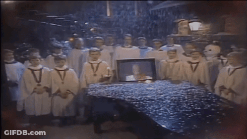 Men In White Robes Around Table With Picture GIF