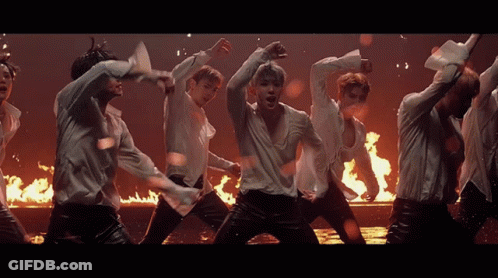 Men In White Shirts Dancing In Front Of Fire GIF