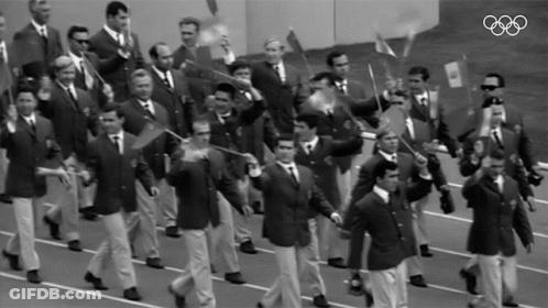 Men Marching In Parade With Olympic Rings GIF