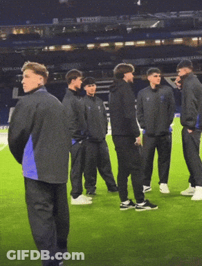 Men On Soccer Field With UEFA Champions League Sign GIF