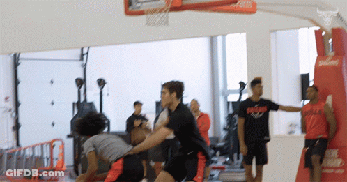 Men Playing Basketball One Wearing Bulls Shirt GIF