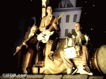 Men Playing Instruments In Front Of SD Sign GIF