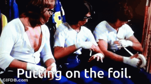 Men Putting On Foil In Dark Room GIF