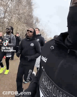 Men Running In Park One Wearing Armour Shirt GIF
