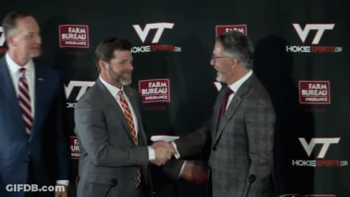 Men Shaking Hands In Front Of Farm Bureau Insurance Wall GIF