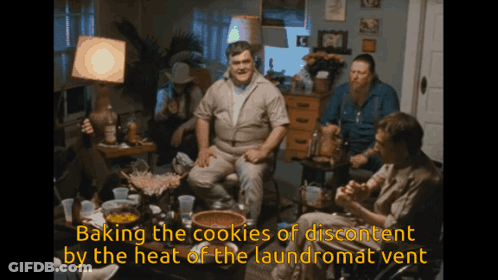 Men Sitting Around Table Baking The Cookies Of Discontent By The Heat Of The Laundromat Vent GIF
