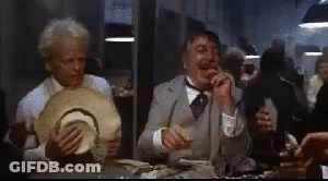Men Sitting At Table Eating And Drinking In Dark Room GIF