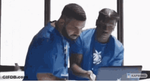 Men Sitting At Table Looking At Laptop GIF