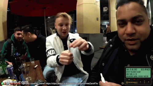 Men Sitting At Table One Wearing ND Jacket GIF