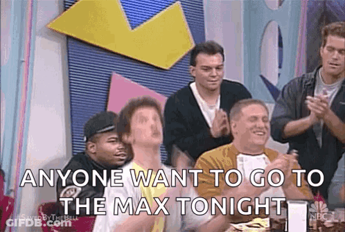 Men Sitting At Table With Hands In Air GIF