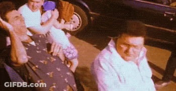Men Sitting In Front Of Car Talking On Cell Phones GIF