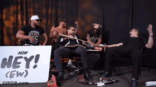 Men Sitting In Front Of Hey Ew Sign GIF