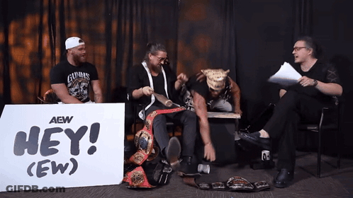 Men Sitting In Front Of Hey (Ew) Sign GIF
