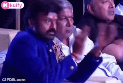 Men Sitting In Row, One In Blue Jacket Tie GIF