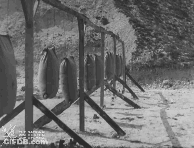 Men Stabbing Hanging Stuffed Sacks GIF