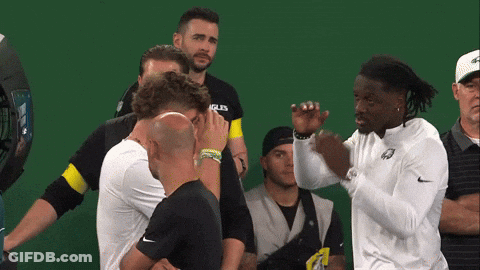 Men Standing Around Man In Eagles Shirt GIF