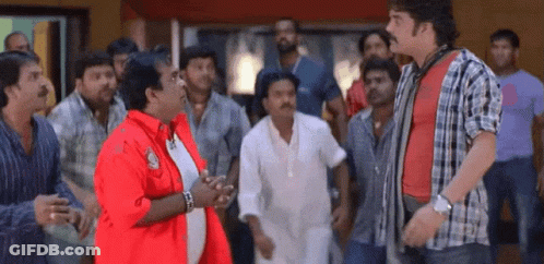 Men Standing Around Man In Red Jacket GIF