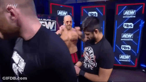 Men Standing Beside AEW Sign GIF