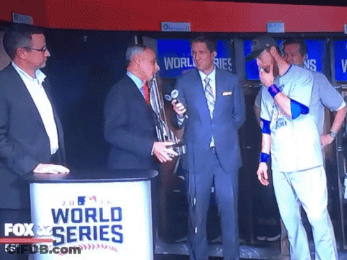Men Standing In Front Of Fox World Series Sign GIF