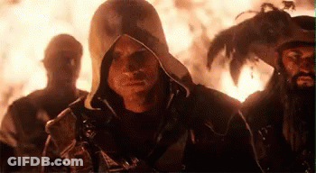 Men Standing Near Fire, One Hooded GIF