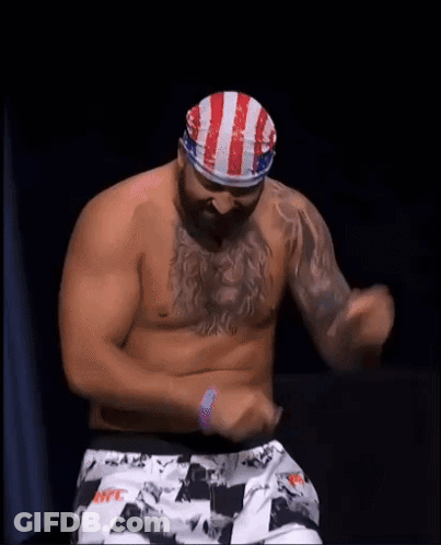 Men Surrounding Bald Man In Boxing Ring GIF