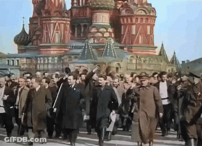 Men Walking In Front Of Red Building GIF