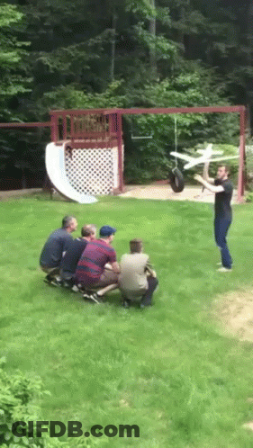Men Watching Man Throwing Toy Airplane GIF