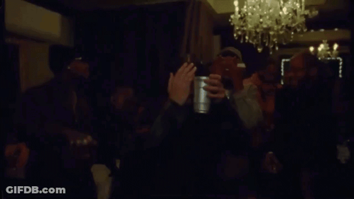 Men Waving Bottles In Dark Room GIF