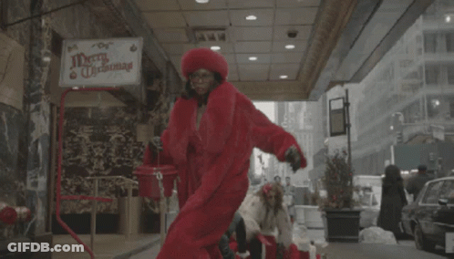 Merry Christmas Sign Above Woman In Red Coat GIF