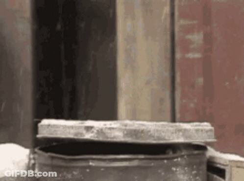 Metal Container With Lid In Front Of Building GIF