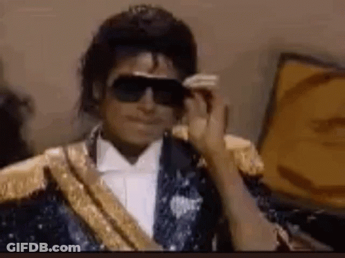 Michael Jackson Is Wearing Sunglasses And A Tuxedo . GIF