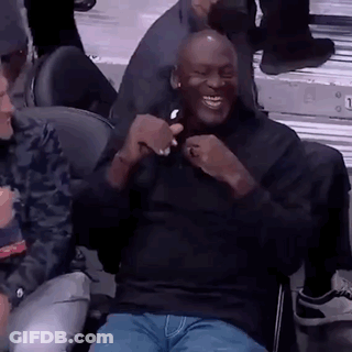 Michael Jordan Is Sitting In The Stands At A Basketball Game Laughing And Holding A Cell Phone . GIF