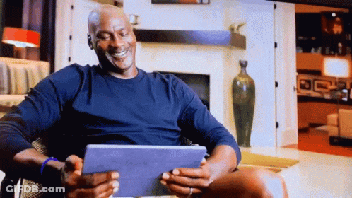 Michael Jordan Is Smiling While Looking At His Tablet GIF